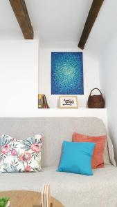 a living room with a couch with pillows and a painting at Studio Tony in Dubrovnik