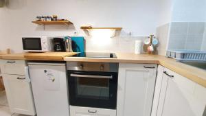 a kitchen with white cabinets and a stove top oven at Studio Tony in Dubrovnik