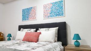 a bedroom with a bed with three paintings on the wall at Studio Tony in Dubrovnik