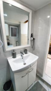 a white bathroom with a sink and a mirror at Studio Tony in Dubrovnik