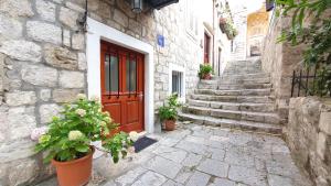 an alley with a red door and some potted plants at Studio Tony in Dubrovnik
