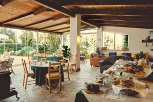 a dining room with tables and chairs and windows at Casa Consalvo B&b in Pontecagnano