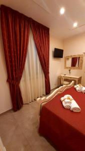 a hotel room with a red bed and a window at B&B Orchidea in Gioia Tauro
