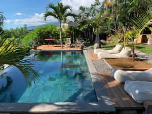 a swimming pool with chaise lounges next to a resort at La Kaz Nana Sakifo - Maison d'hotes in Saint-Paul