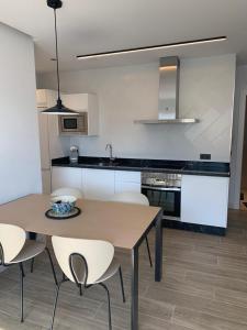 a kitchen with a wooden table and white chairs at Casa Raquel,caminito del Rey in Valle de Abdalagís +10 photos