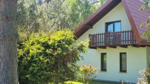 Casa con balcón y árbol en Dom przy lesie. Ostrowo en Ostrowo