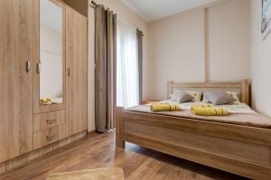 een slaapkamer met een houten bed en een groot raam bij Dom B Apartments in Budva