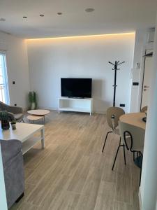 a living room with a television and tables and chairs at Casa Raquel,caminito del Rey in Valle de Abdalagís