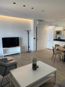 a living room with a table and chairs and a kitchen at Casa Raquel,caminito del Rey in Valle de Abdalagís