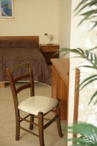 1 dormitorio con silla, escritorio y cama en Hotel Sofia, en Catania
