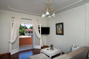 a living room with a couch and a chandelier at Georgia's Apartments, Ipsos - Complex S in Ýpsos