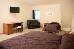 a bedroom with a bed and a desk and a chair at Hotel Sofia in Catania