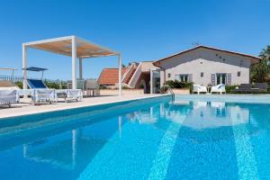 - une piscine avec des chaises et une maison dans l'établissement Splendida Villa con vista mozzafiato e piscina, à Terrasini