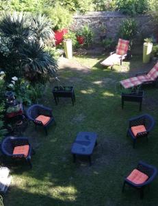 eine Gruppe von Stühlen und Tischen in einem Hof in der Unterkunft LA MAISON DU BIEN ETRE o in Alès