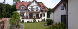 a large white house with a yard at Pelikan in Niechorze