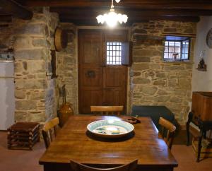 a dining room with a wooden table and a stone wall at Helikon -la dimora del viandante- in Montalbano Elicona