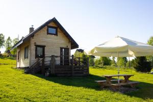 a picnic table and an umbrella in front of a house at Chata Umilajka in Czarna