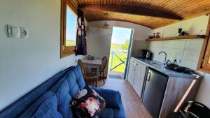 a living room with a blue couch in a kitchen at Tisza White House in Tiszaszőlős