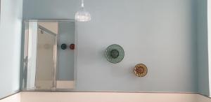 a mirror in a bathroom with a shower and a clock at B&B Giro Di Boa in Lampedusa