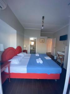 a bedroom with a large bed with a red headboard at AEGEAN VIEW SEASIDE ROOMS AND STUDIOS KEA in Korissia