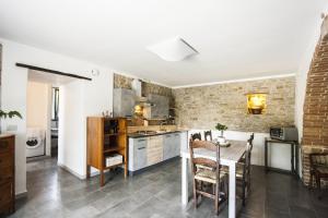 cocina y comedor con mesa y sillas en B&B Appartamento - IL RIONE, en Loreto Aprutino