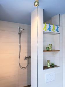a bathroom with a shower with a glass door at Das Nachtwächterhäuschen in Tecklenburg +15 photos