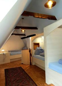 a attic room with two beds and a rug at Das Nachtwächterhäuschen in Tecklenburg