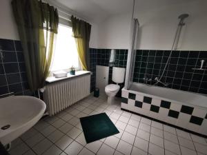 a bathroom with a tub and a toilet and a sink at Ferienwohnung Brunschön in Bruchhausen-Vilsen