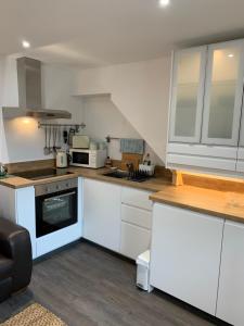 a kitchen with white cabinets and a stove top oven at Pannanich View Cottage, Ballater in Ballater