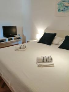 1 cama blanca grande con 2 toallas en Room Mina, en Rovinj