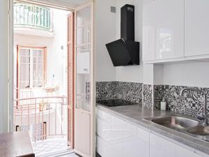 een witte keuken met een wastafel en een raam bij Nice, 58 M2 ! superbe appartement climatisé, 3 couchages, proche de la promenade des Anglais et de la Gare ! in Nice