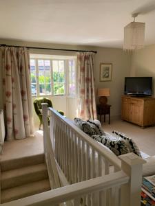 a room with a crib and a tv and a window at Wee Grange in Bath