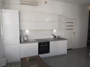 a white kitchen with a sink and a stove at Apartment for you 2 Królewiecka 21 in Mrągowo