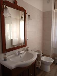 uma casa de banho com um lavatório, um WC e um espelho. em La Cjase di Pieri e Vilme em Udine