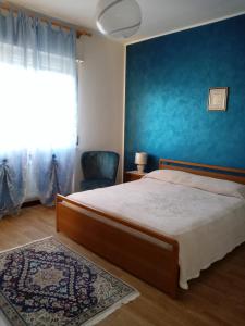 1 dormitorio con cama y pared azul en La Cjase di Pieri e Vilme, en Udine