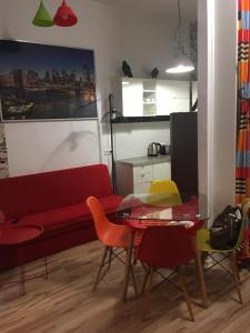 un salon avec un canapé rouge et une table dans l'établissement Apartament Pod Wroną, à Toruń 5 autres photos