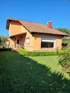une maison avec une cour d'herbe devant elle dans l'établissement Casa de campo Aires de Gredos, à Candeleda