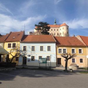 a large white building with a castle in the background at New Fajka in Mikulov