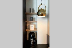 a room with a lamp and a coffee maker on a shelf at Lovely apr with sauna at the best area of Oulu in Oulu