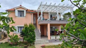 une villa avec un balcon et une maison dans l'établissement Apartmani Villa Lilliana, à Tribunj