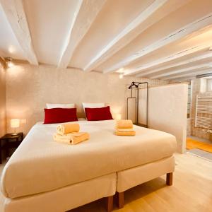 a bedroom with a large bed with towels on it at Le Lavoir aux Roses by Gîtes Sud Touraine in Chédigny
