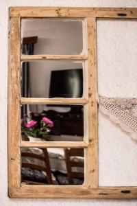 uma janela de madeira com uma televisão na parede em Ámbitus-ház em Egerszalók