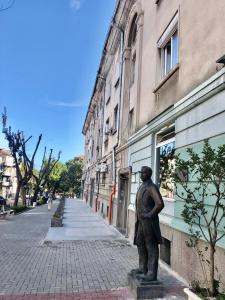 a statue of a man standing on a street at Nõma studio in Varna City
