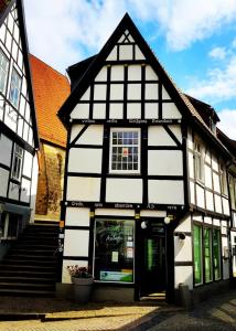 un bâtiment noir et blanc avec un magasin dans l'établissement Das Nachtwächterhäuschen, à Tecklembourg