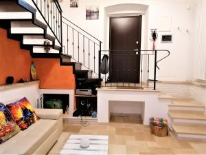 ein Wohnzimmer mit einem Sofa und einer Treppe in der Unterkunft Regina Viarum Apartment, Historic City Centre in Brindisi