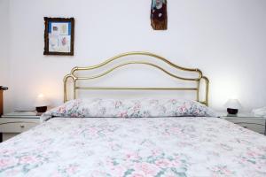 1 dormitorio con 1 cama con colcha de flores en Rooms Torcello - with shared bathroom, en Portorož