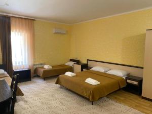 アルヒーポ・オシポフカにあるGuest House Adelの黄色の壁のホテルルーム(ベッド2台付)