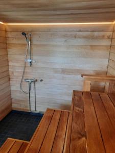 una sauna con una mesa de madera y una ducha en Villa Hiili en Ähtäri
