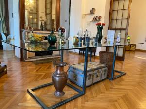 a glass table with vases on it in a room at Hotel La Fontana in Stresa