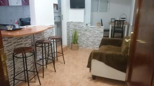 a kitchen with a bar and stools in a room at Casa Relajación in Santa Cruz de Tenerife